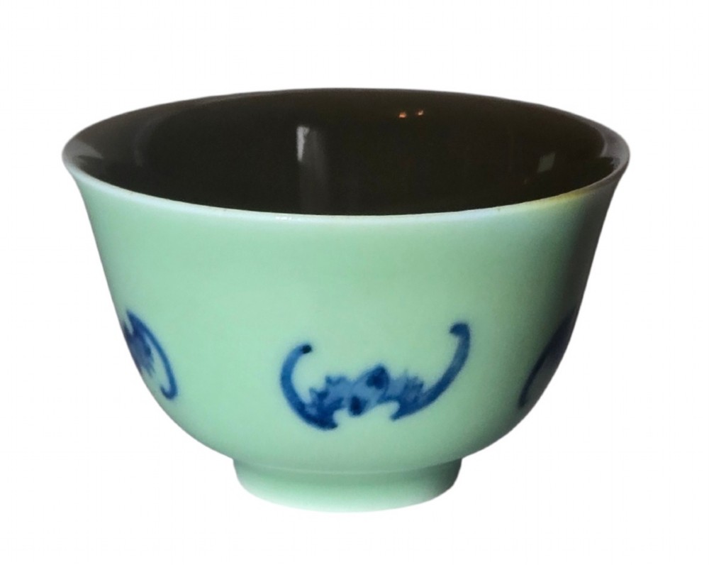 A small Chinese celadon green glazed porcelain cup decorated with underglaze blue bat motifs around the exterior. View II