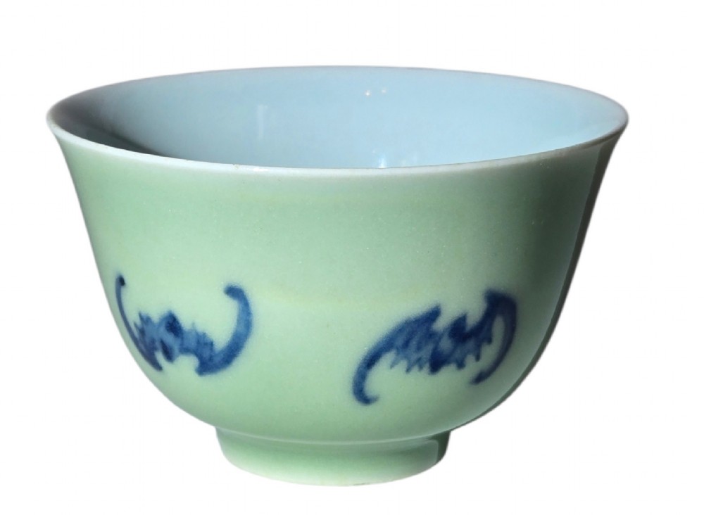 A small Chinese celadon green glazed porcelain cup decorated with underglaze blue bat motifs around the exterior. View VI