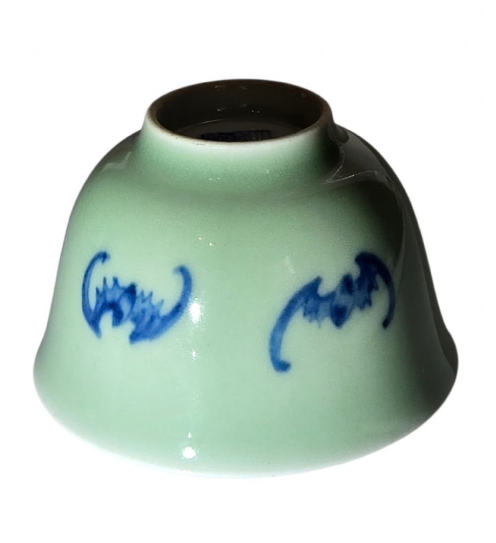 A small Chinese celadon green glazed porcelain cup decorated with underglaze blue bat motifs around the exterior. View VII