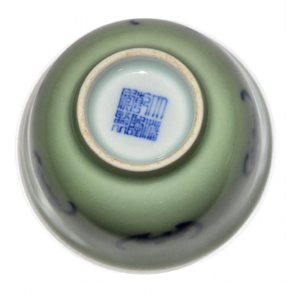 A small Chinese celadon green glazed porcelain cup decorated with underglaze blue bat motifs around the exterior. View IX