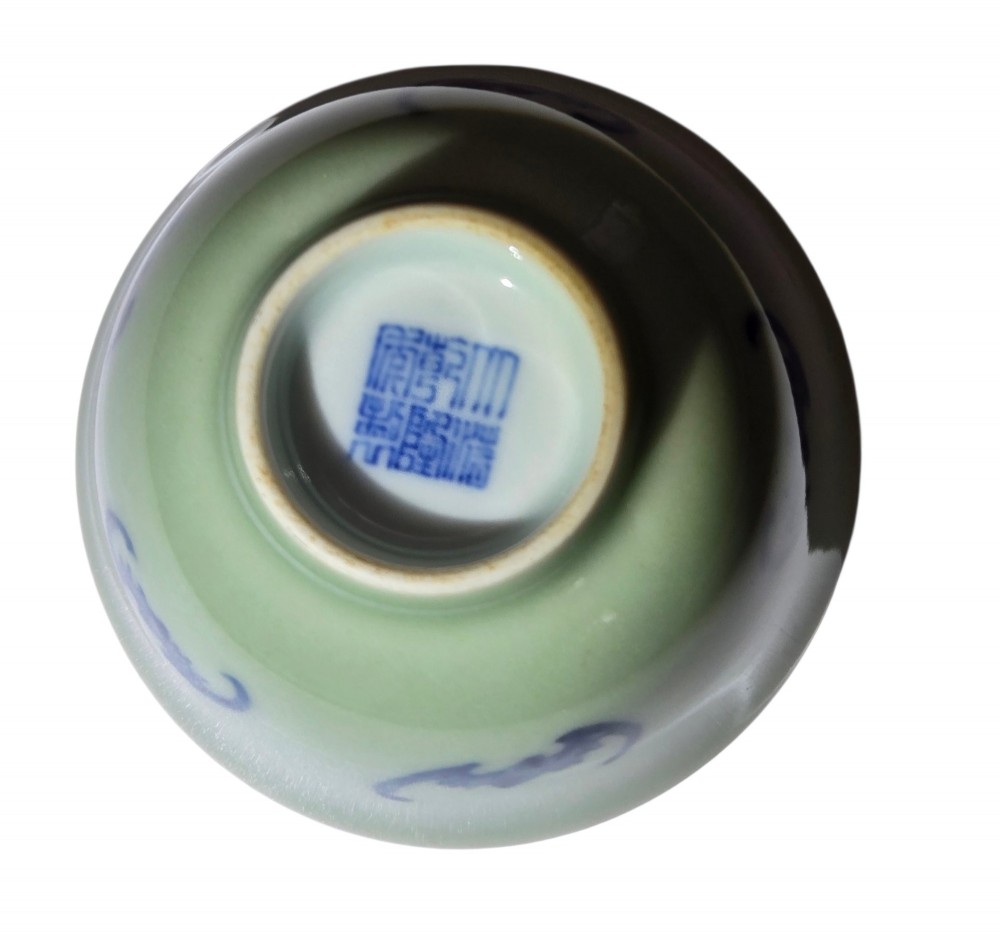A small Chinese celadon green glazed porcelain cup decorated with underglaze blue bat motifs around the exterior. View X
