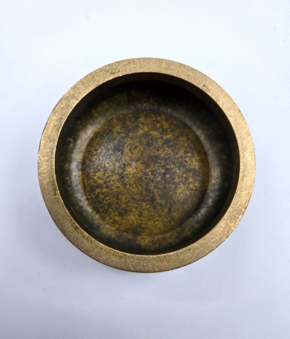 Underside view of a heavy bronze tripod censer displaying three short feet and a square recessed seal mark filled with turquoise oxidisation. View III