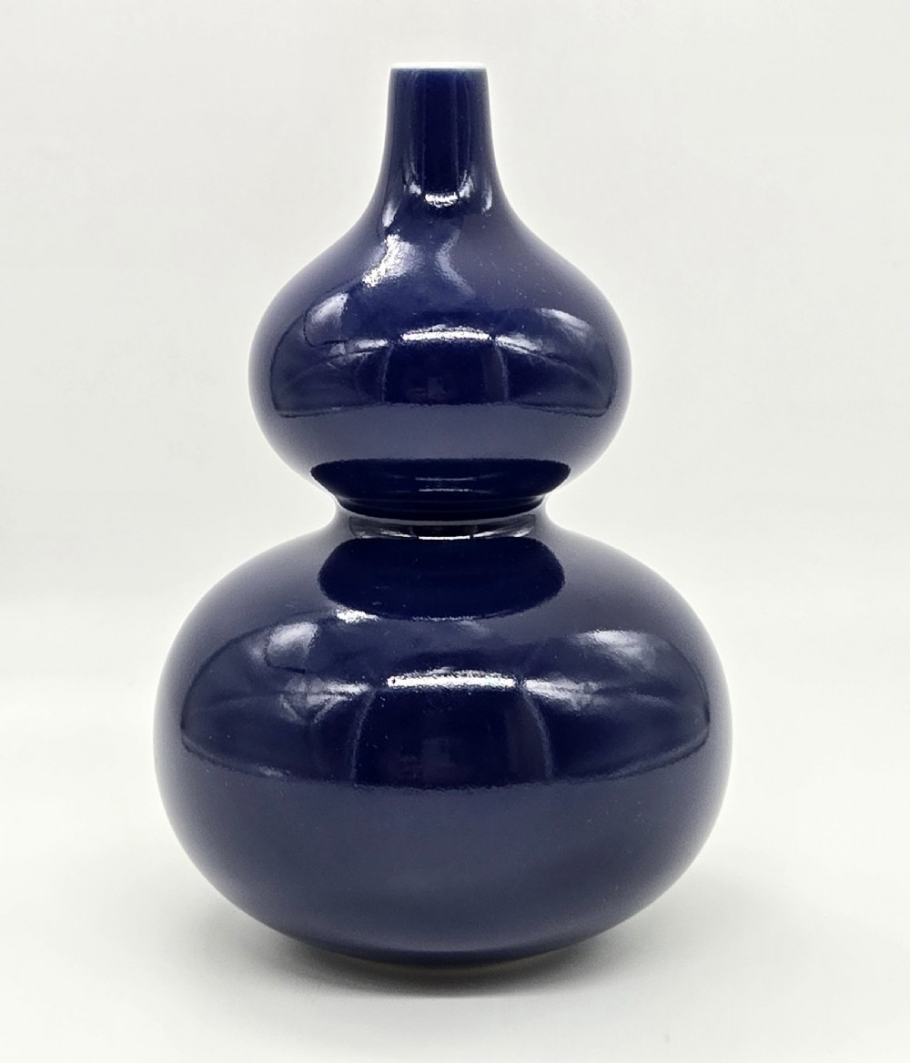 A glossy deep cobalt blue glazed porcelain vase crafted in a classic double-gourd silhouette against a white backdrop. View VI