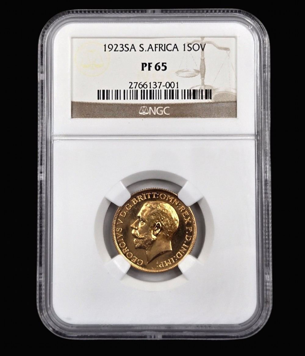 A 1923 South Africa gold sovereign coin featuring the bare head profile portrait of King George V, encapsulated in a white plastic NGC PF 65 grading slab.