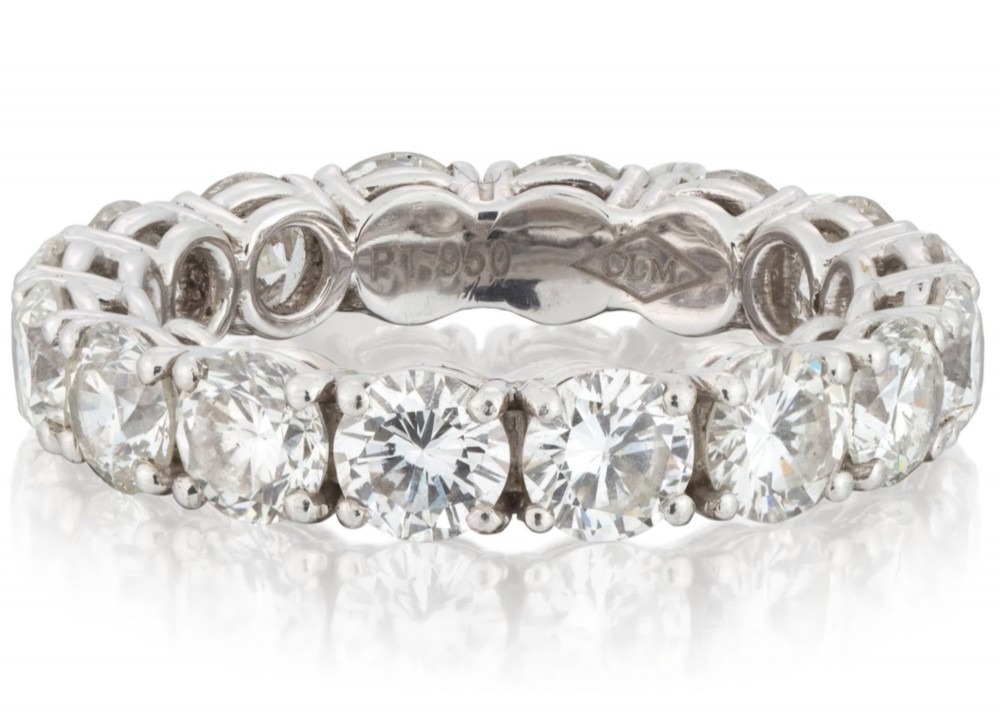 A platinum full eternity ring set with round brilliant diamonds, displayed inside its original black leather Kutchinsky box. View IV