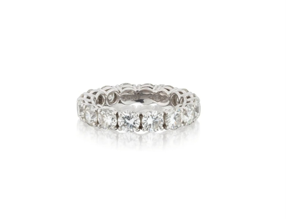 A platinum full eternity ring set with round brilliant diamonds, displayed inside its original black leather Kutchinsky box. View VI