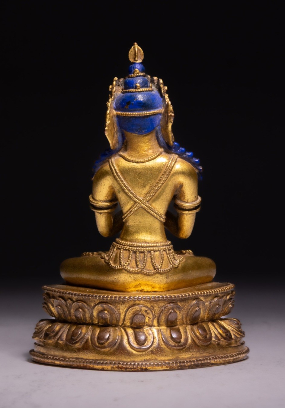 An 18th-century Sino-Tibetan gilt-bronze figure depicting the deity Vajradhara seated in meditation upon a double lotus pedestal. View II