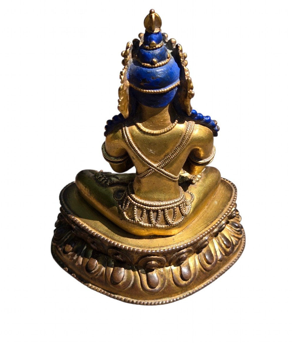 An 18th-century Sino-Tibetan gilt-bronze figure depicting the deity Vajradhara seated in meditation upon a double lotus pedestal. View IX