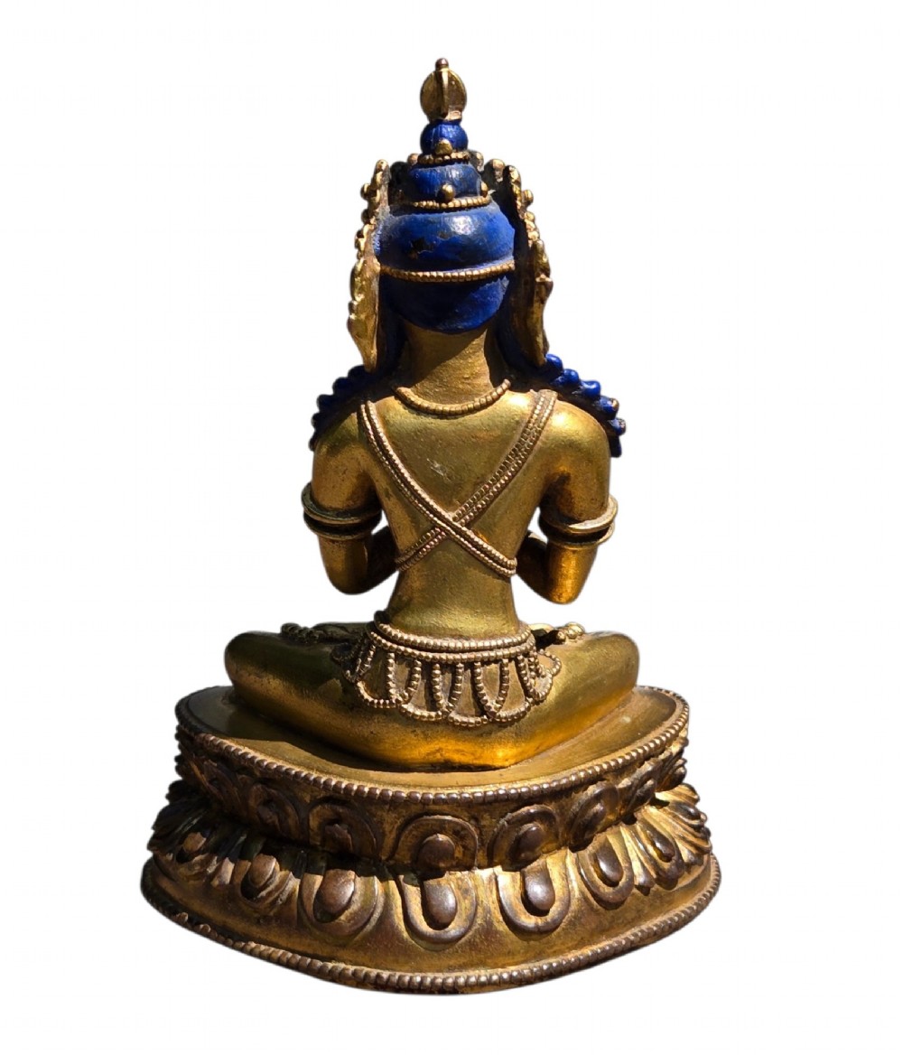 An 18th-century Sino-Tibetan gilt-bronze figure depicting the deity Vajradhara seated in meditation upon a double lotus pedestal. View X