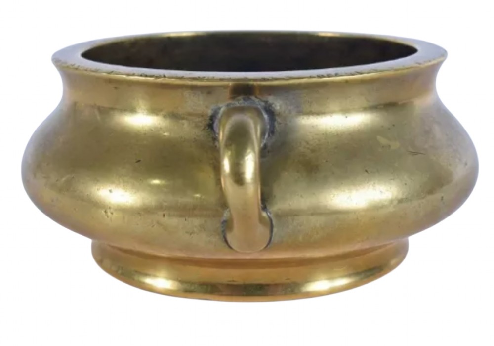 An 18th-century cast bronze incense burner featuring a compressed rounded body, flared rim, two loop handles, and a burnished golden patinated finish. View V