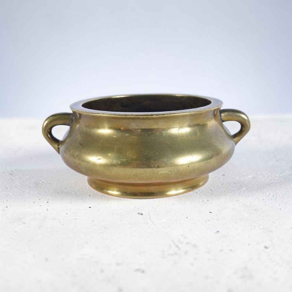 An 18th-century cast bronze incense burner featuring a compressed rounded body, flared rim, two loop handles, and a burnished golden patinated finish. View XI