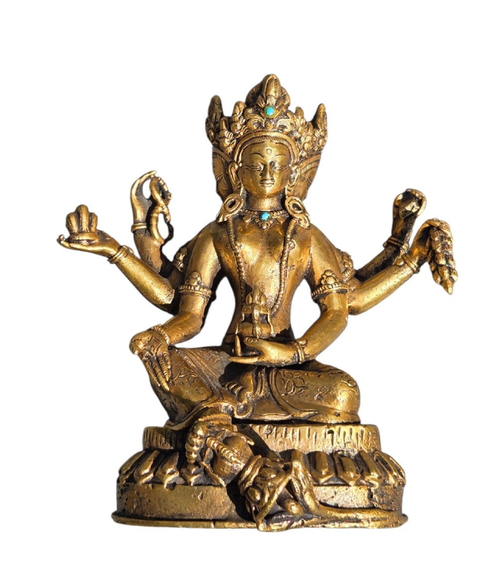 An early 19th-century gilt bronze multi-armed deity figure seated on a lotus base with turquoise stone inlays in the crown. View V