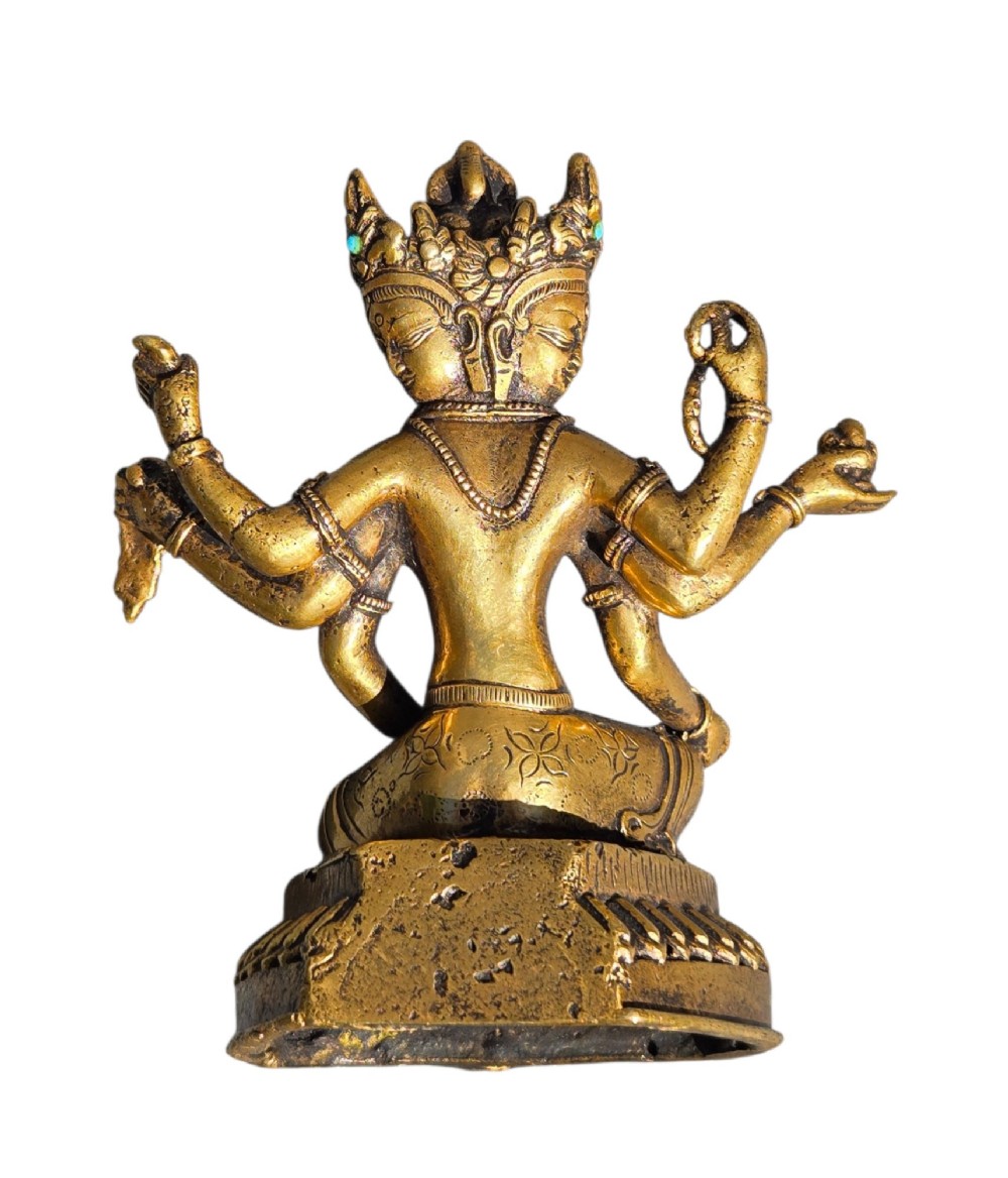 An early 19th-century gilt bronze multi-armed deity figure seated on a lotus base with turquoise stone inlays in the crown. View VI