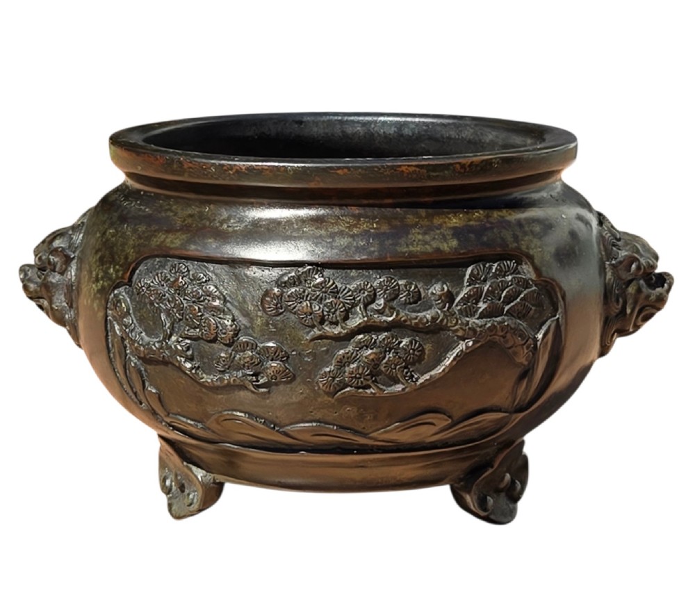 A dark patinated cast bronze incense burner featuring raised relief panels of bamboo and beast mask side handles. View II