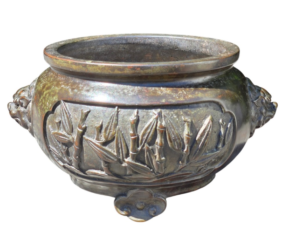 A dark patinated cast bronze incense burner featuring raised relief panels of bamboo and beast mask side handles. View XI