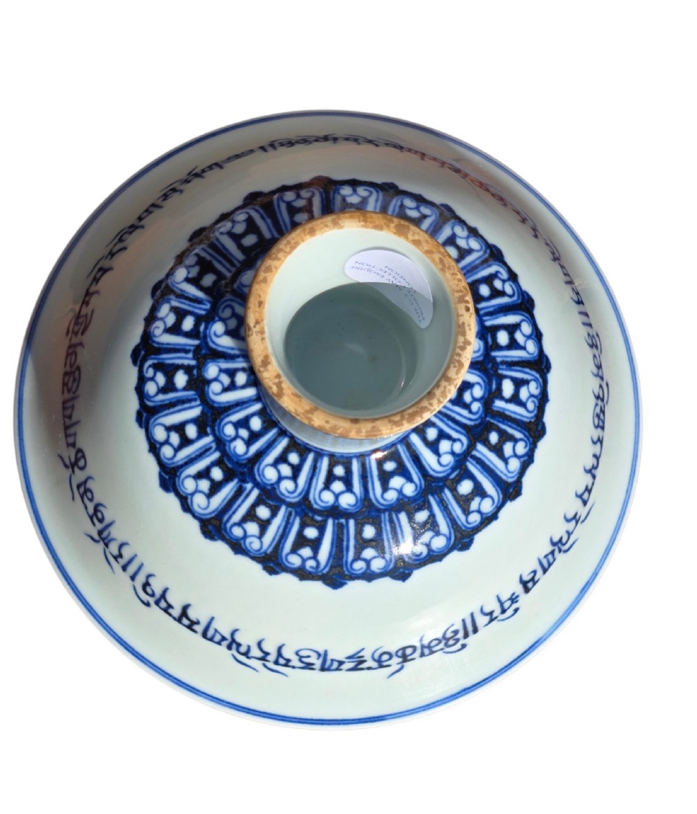 A Chinese blue and white porcelain stem cup featuring Tibetan script around the exterior flared bowl and a hollow cylindrical foot. View VI