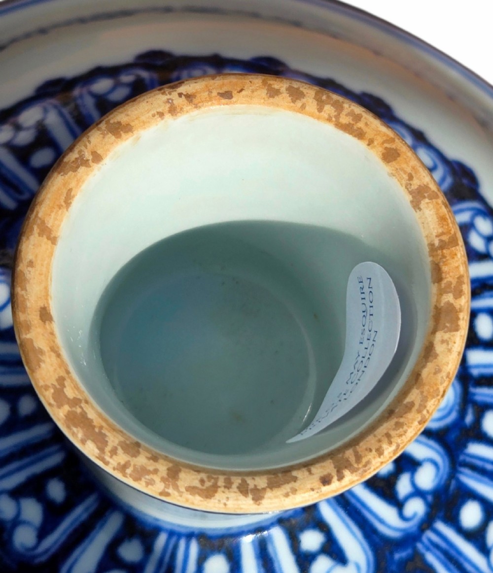 A Chinese blue and white porcelain stem cup featuring Tibetan script around the exterior flared bowl and a hollow cylindrical foot. View X