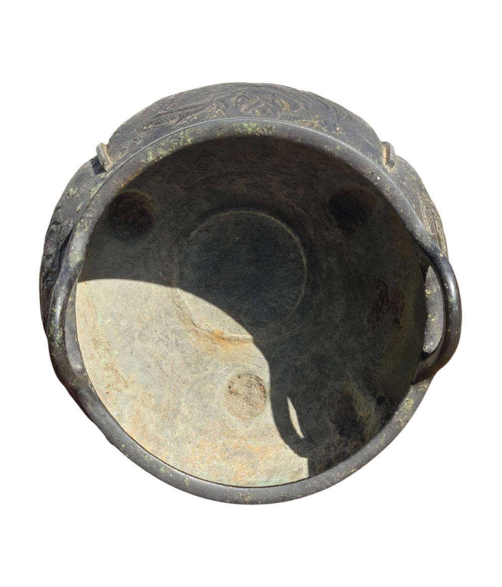 A dark cast bronze tripod censer with loop handles, low feet, and dragon motifs in relief across the exterior. View VI