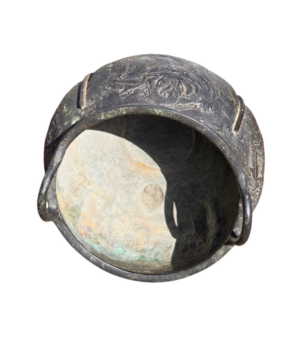 A dark cast bronze tripod censer with loop handles, low feet, and dragon motifs in relief across the exterior. View VII