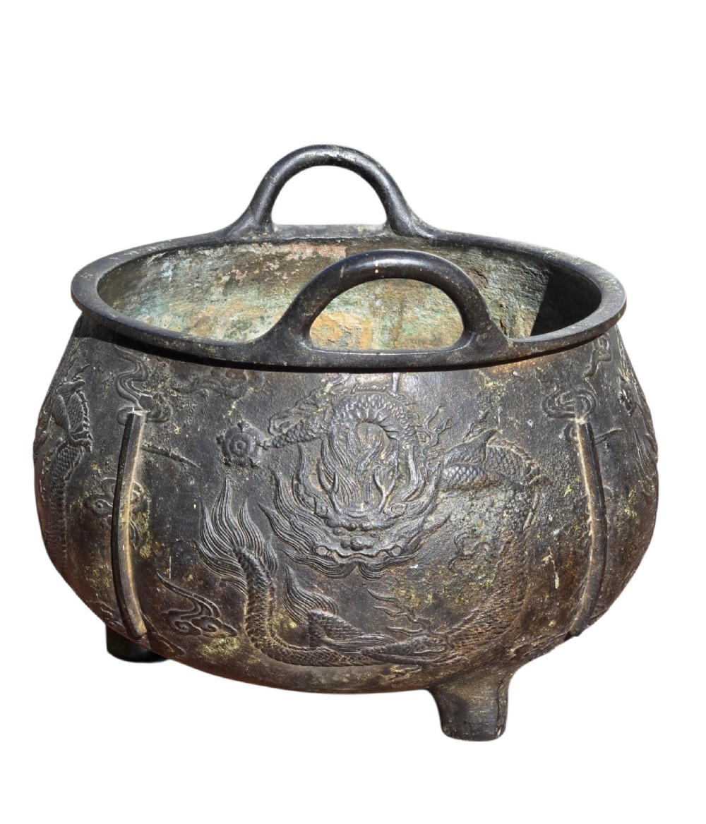 A dark cast bronze tripod censer with loop handles, low feet, and dragon motifs in relief across the exterior. View X
