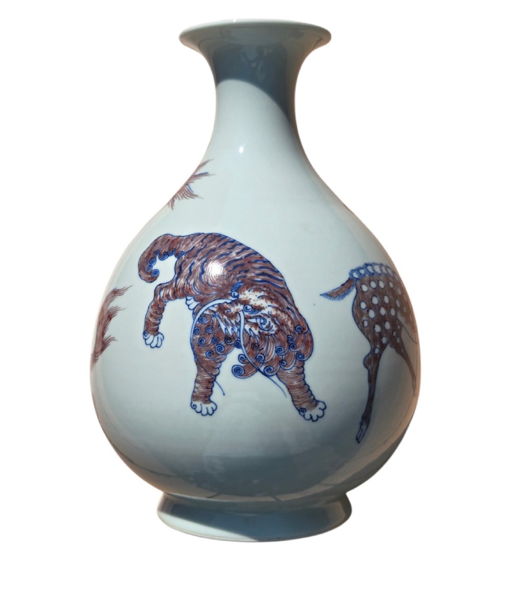 A white porcelain garlic-mouth vase featuring underglaze blue and copper-red painted depictions of mythical beasts. View II
