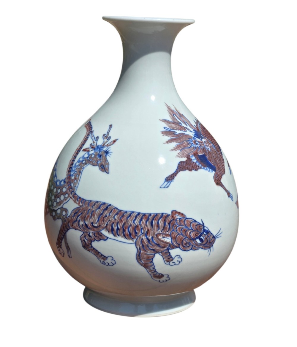 A white porcelain garlic-mouth vase featuring underglaze blue and copper-red painted depictions of mythical beasts. View X