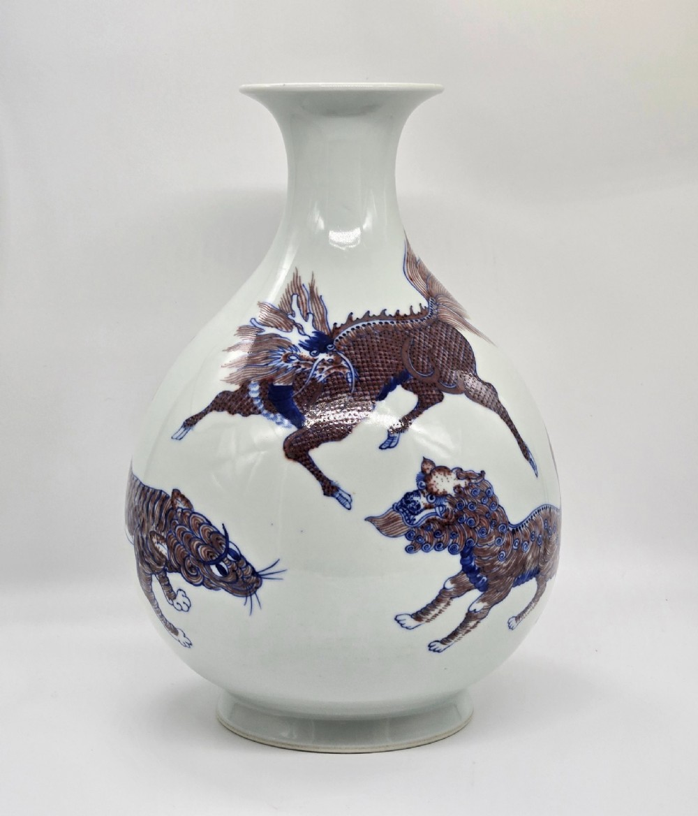 A white porcelain garlic-mouth vase featuring underglaze blue and copper-red painted depictions of mythical beasts. View XIII