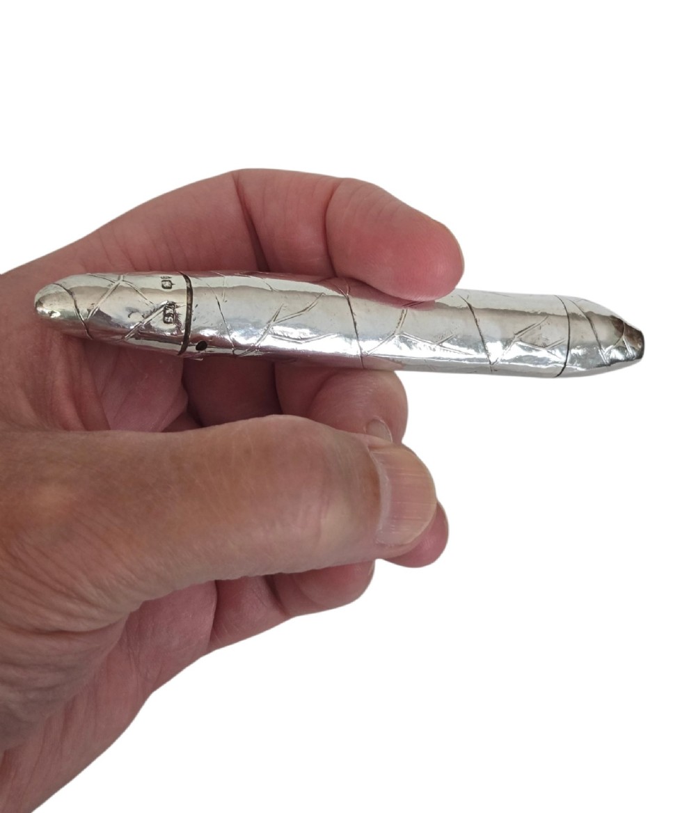 A Victorian sterling silver vesta case crafted in the shape of a double-ended cigar with engraved leaf textures. View II