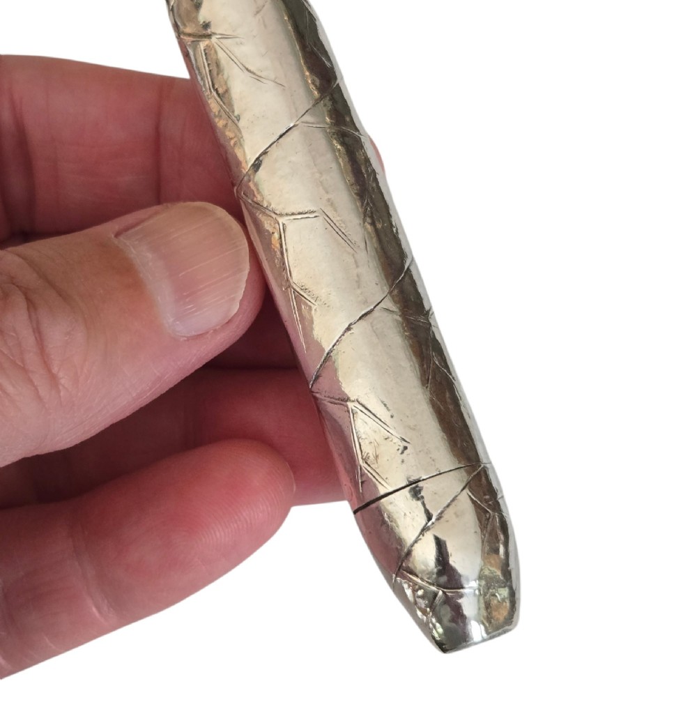 A Victorian sterling silver vesta case crafted in the shape of a double-ended cigar with engraved leaf textures. View VII