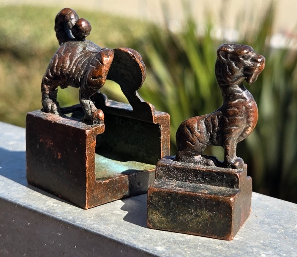 A cast bronze Chinese seal featuring a qilin finial resting atop a square base with reddish brown patination. View IV