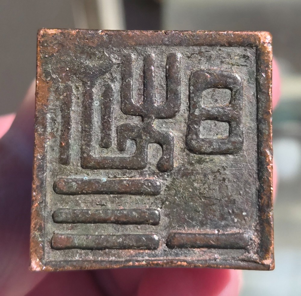 A cast bronze Chinese seal featuring a qilin finial resting atop a square base with reddish brown patination. View VI