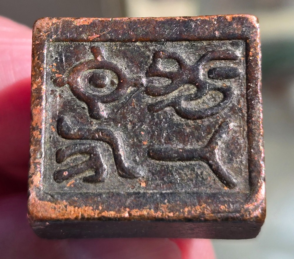 A cast bronze Chinese seal featuring a qilin finial resting atop a square base with reddish brown patination. View VII