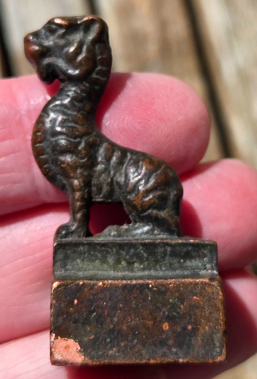 A cast bronze Chinese seal featuring a qilin finial resting atop a square base with reddish brown patination. View IX