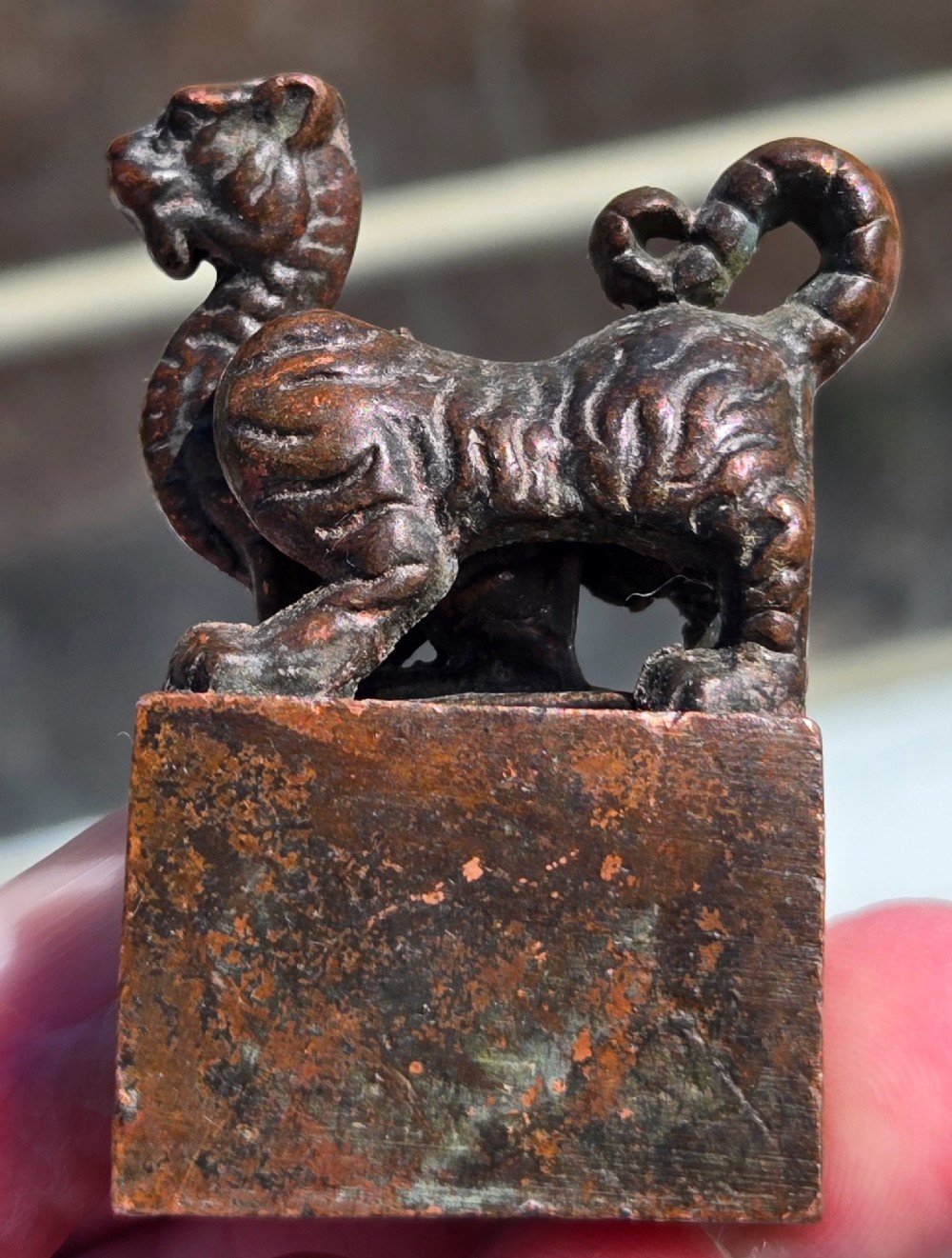 A cast bronze Chinese seal featuring a qilin finial resting atop a square base with reddish brown patination. View XI