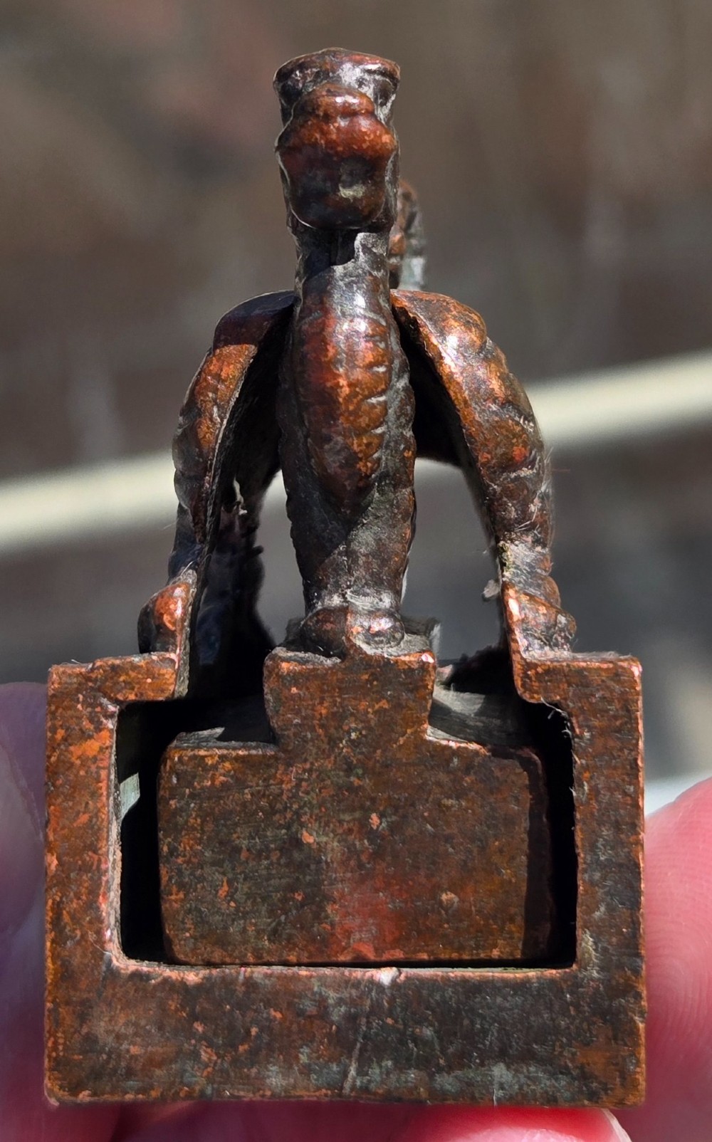 A cast bronze Chinese seal featuring a qilin finial resting atop a square base with reddish brown patination. View XII