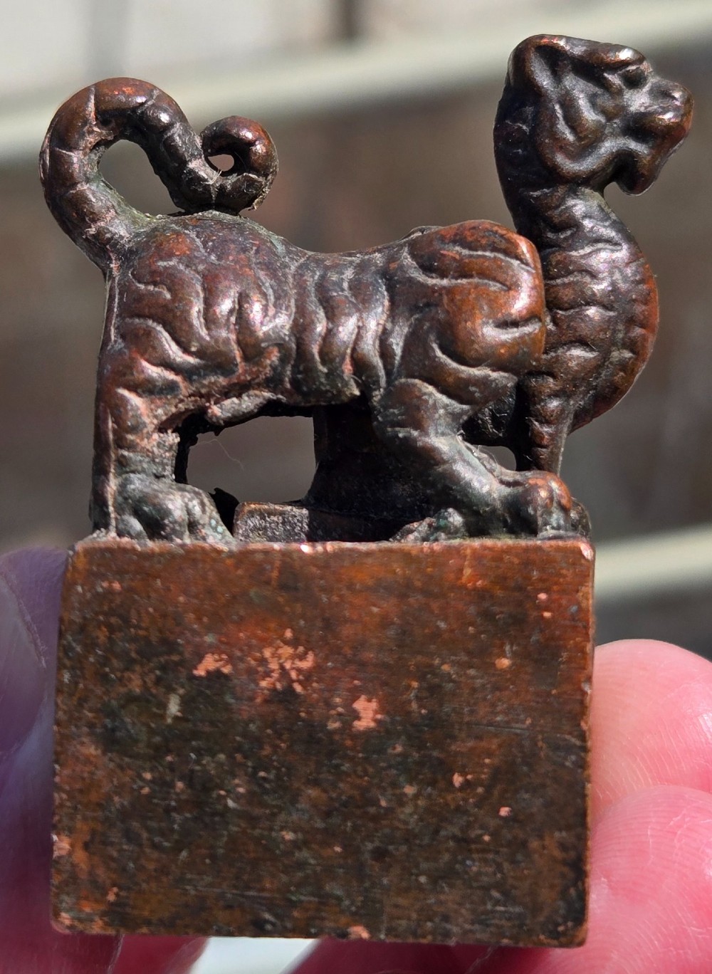 A cast bronze Chinese seal featuring a qilin finial resting atop a square base with reddish brown patination. View XIII