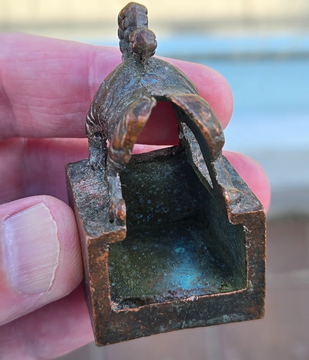 A cast bronze Chinese seal featuring a qilin finial resting atop a square base with reddish brown patination. View XV