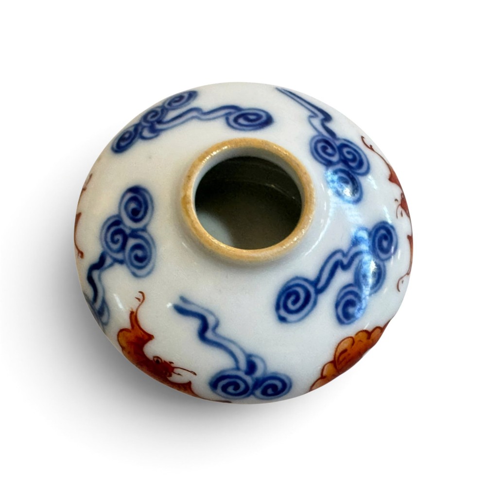 A squatted Chinese porcelain brush washer decorated with underglaze cobalt blue clouds and copper red bats on a white glazed ground. View II
