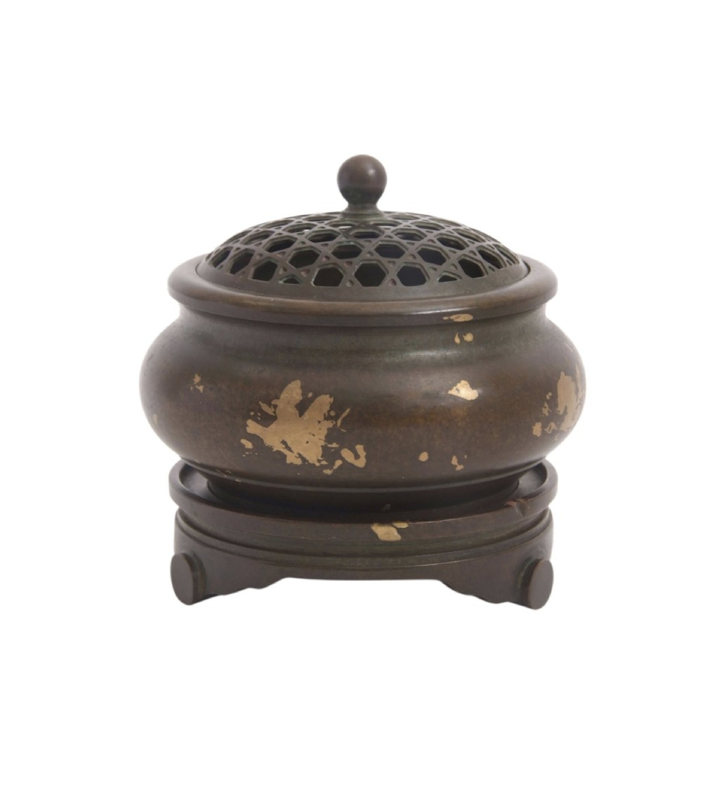 A dark brown bronze circular censer featuring gold splash decoration, a reticulated lattice cover with a spherical finial, and a matching footed bronze stand. View II