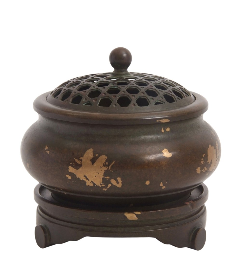 A dark brown bronze circular censer featuring gold splash decoration, a reticulated lattice cover with a spherical finial, and a matching footed bronze stand. View VI