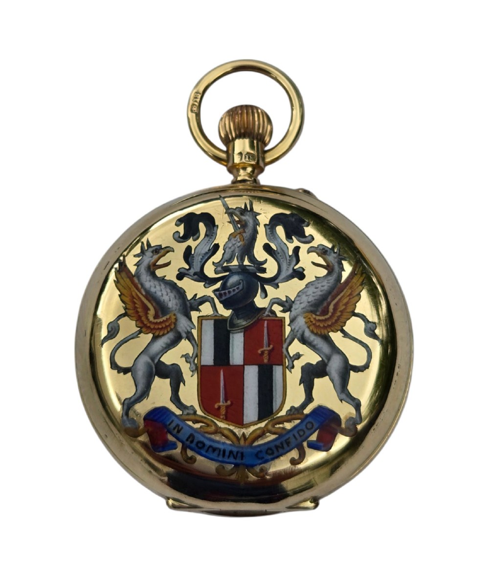 An 18-karat gold Victorian pocket watch casing displaying a polychrome enamelled coat of arms flanked by griffin supporters and a heraldic motto banner. View IX