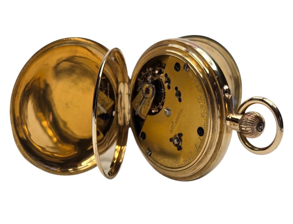 An 18-karat gold Victorian pocket watch casing displaying a polychrome enamelled coat of arms flanked by griffin supporters and a heraldic motto banner. View X