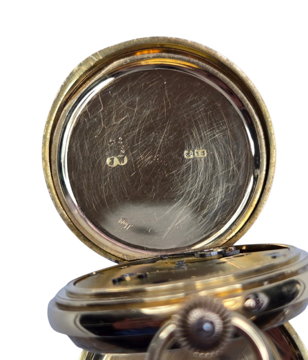An 18-karat gold Victorian pocket watch casing displaying a polychrome enamelled coat of arms flanked by griffin supporters and a heraldic motto banner. View XI