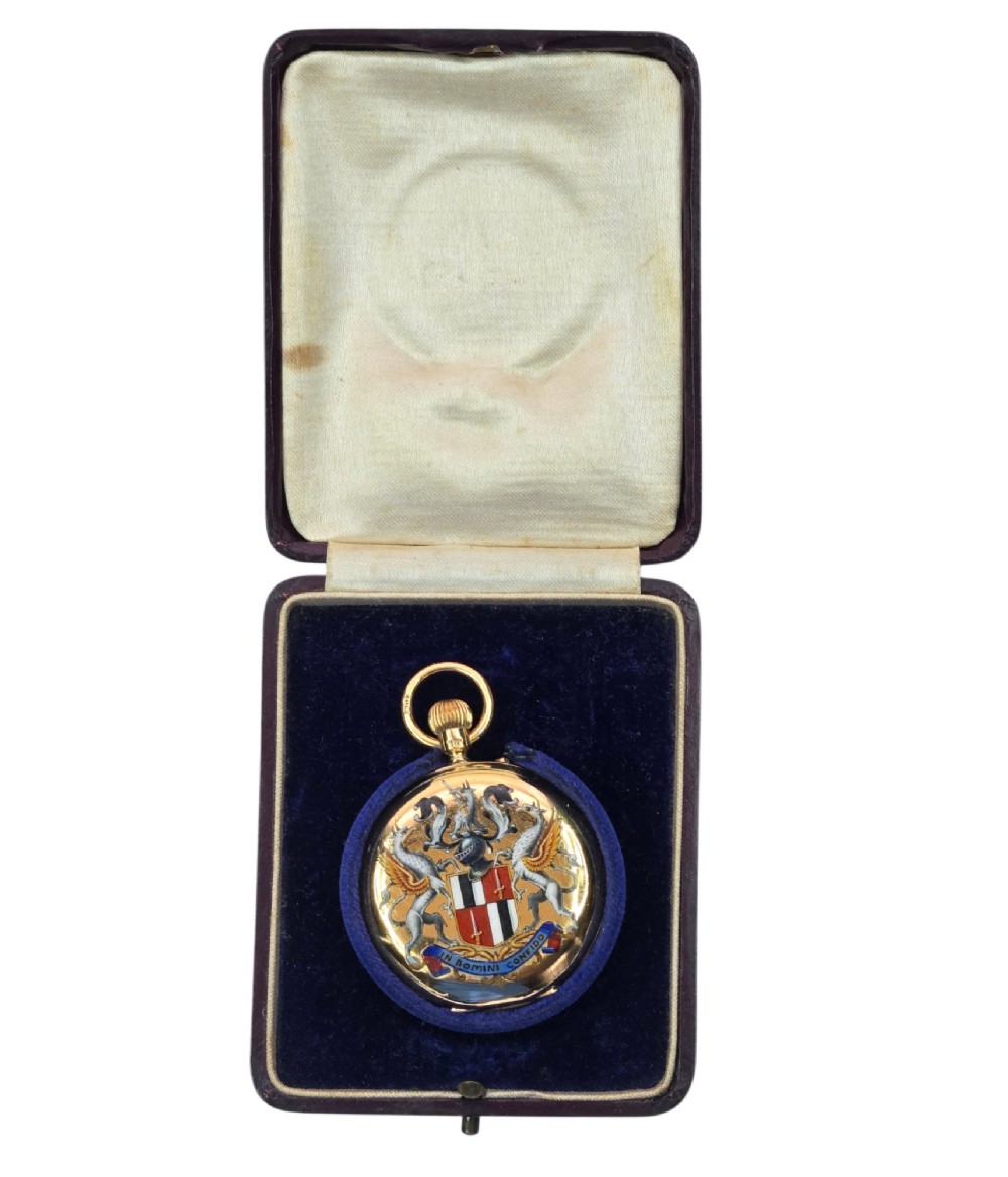 An 18-karat gold Victorian pocket watch casing displaying a polychrome enamelled coat of arms flanked by griffin supporters and a heraldic motto banner. View XIV
