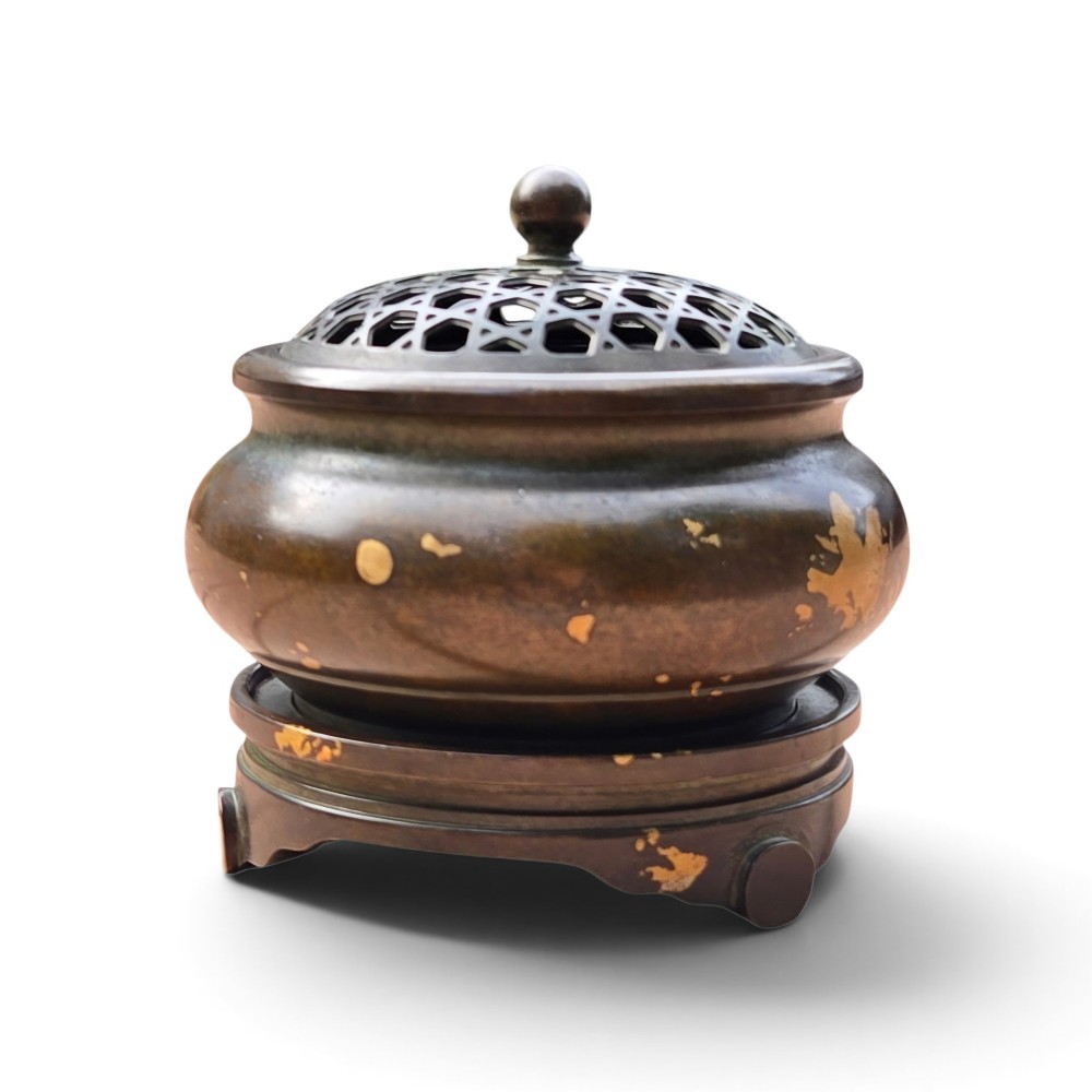 A dark brown bronze circular censer featuring gold splash decoration, a reticulated lattice cover with a spherical finial, and a matching footed bronze stand. View XV