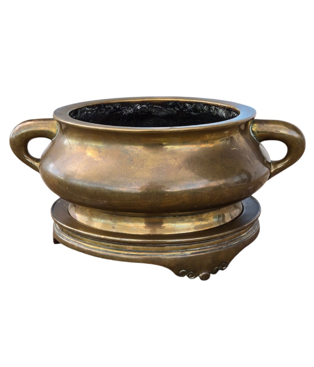 A heavy Chinese bronze ritual censer featuring twin loop handles and resting on a matching fitted base with shaped feet. View XI
