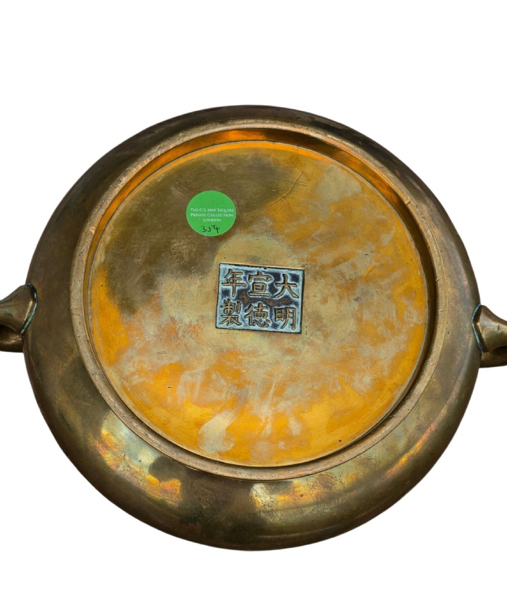 A heavy Chinese bronze ritual censer featuring twin loop handles and resting on a matching fitted base with shaped feet. View XII