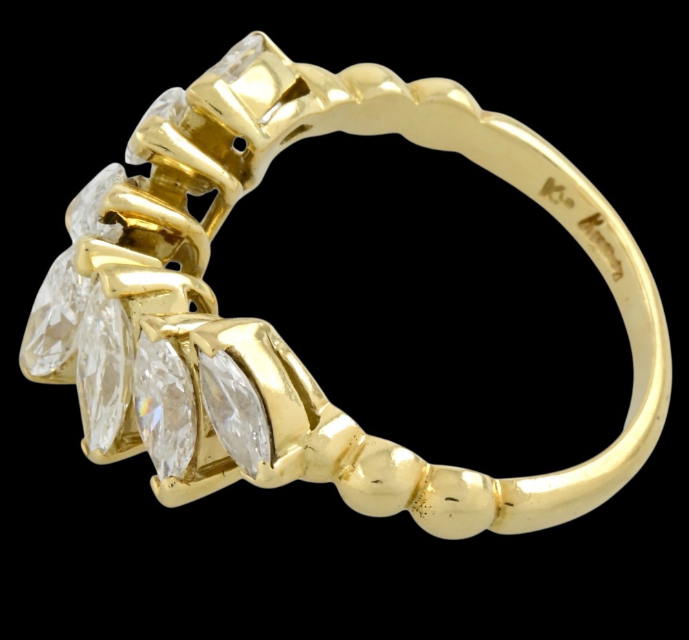 An 18ct yellow gold dress ring by Kutchinsky featuring a graduated row of marquise-cut diamonds mounted on a textured beaded shank. View II