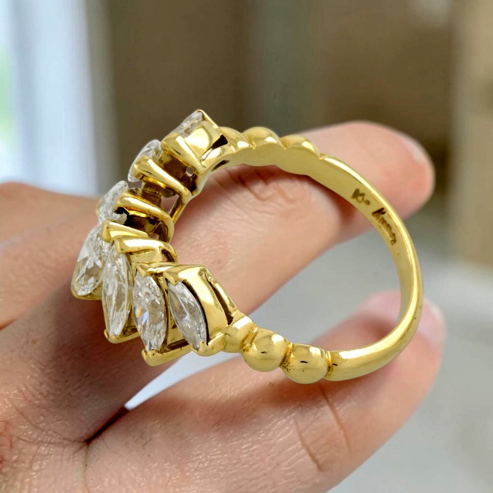 An 18ct yellow gold dress ring by Kutchinsky featuring a graduated row of marquise-cut diamonds mounted on a textured beaded shank. View VII