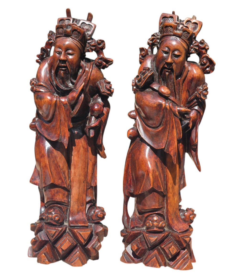 A pair of Chinese hardwood sculptures depicting Daoist immortals in flowing robes with carved geometric bases. View VI